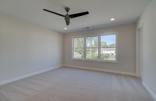 carpeted spare room featuring ceiling fan