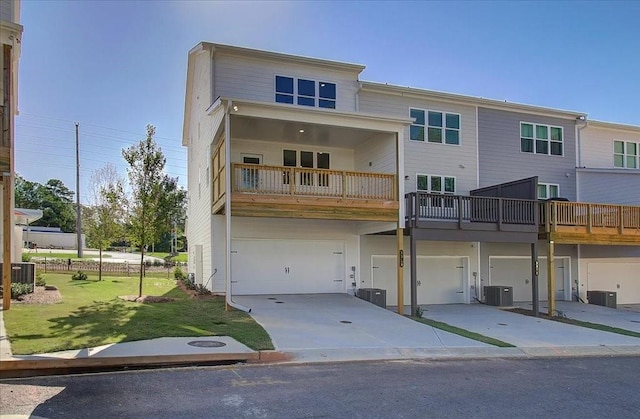 back of house with central AC, a balcony, and a lawn