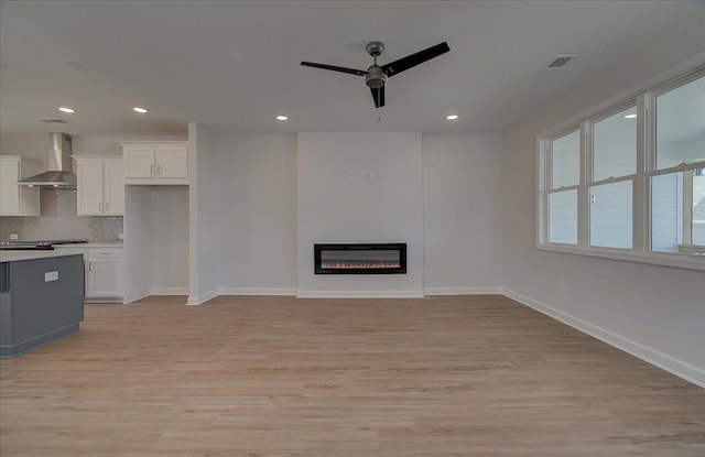 unfurnished living room featuring light hardwood / wood-style floors and ceiling fan