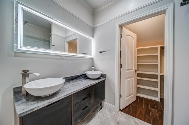 bathroom with crown molding, hardwood / wood-style floors, and vanity