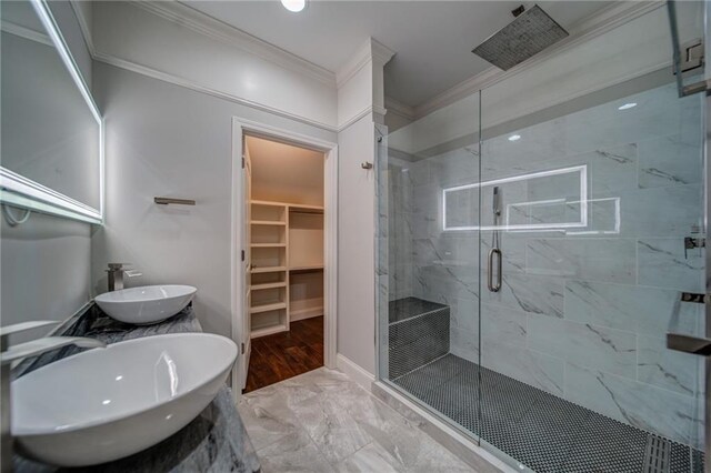 bathroom featuring hardwood / wood-style flooring, walk in shower, crown molding, and sink