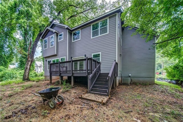 rear view of property featuring a wooden deck and central AC