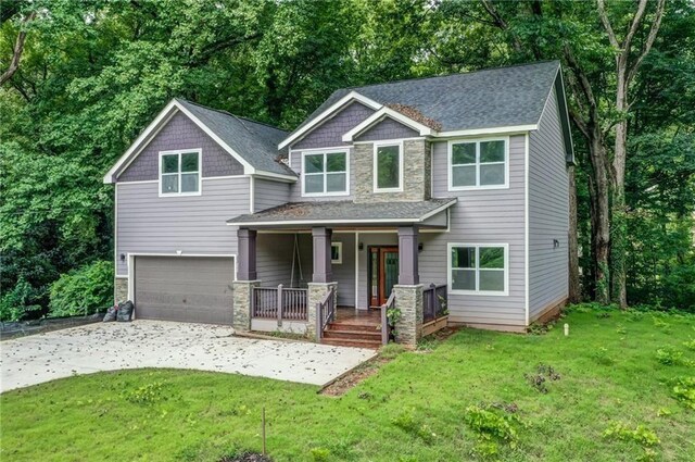 view of front of house featuring a porch, a garage, and a front yard