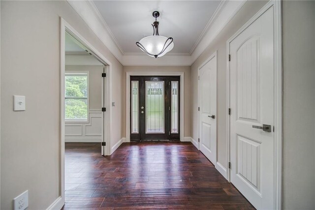 entrance foyer with dark hardwood / wood-style floors and crown molding