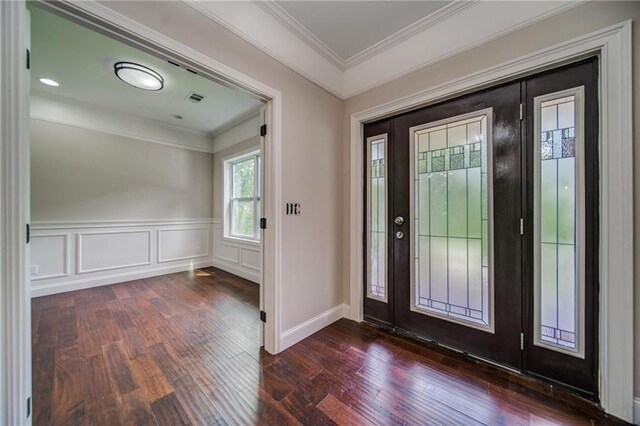 foyer with ornamental molding and dark wood-type flooring