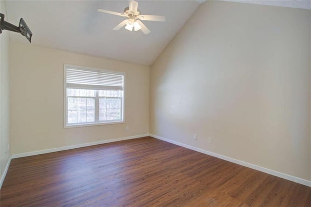 spare room with baseboards, dark wood finished floors, a ceiling fan, and vaulted ceiling