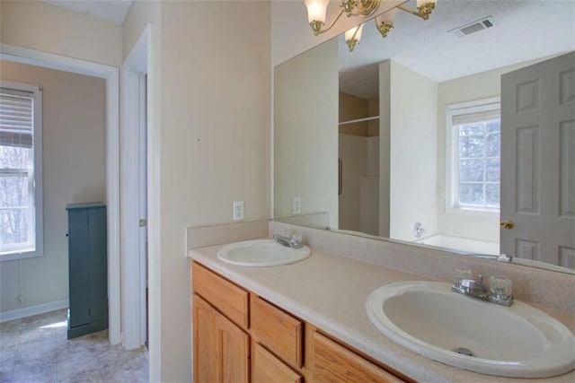 bathroom featuring double vanity, visible vents, a shower, and a sink