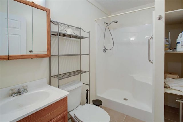 full bathroom featuring tile patterned flooring, toilet, vanity, and a walk in shower