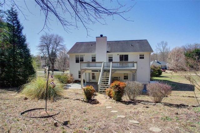 back of property featuring a deck, stairway, a patio area, and a chimney