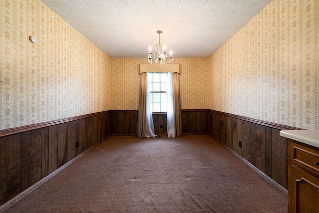 101 Beaver Run, Lagrange, GA 30241 - spare room with a wainscoted wall, a chandelier, wallpapered walls, wood walls, and a textured ceiling