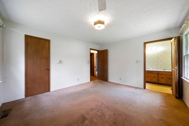 101 Beaver Run, Lagrange, GA 30241 - unfurnished bedroom with light carpet, multiple windows, a textured ceiling, and ensuite bath