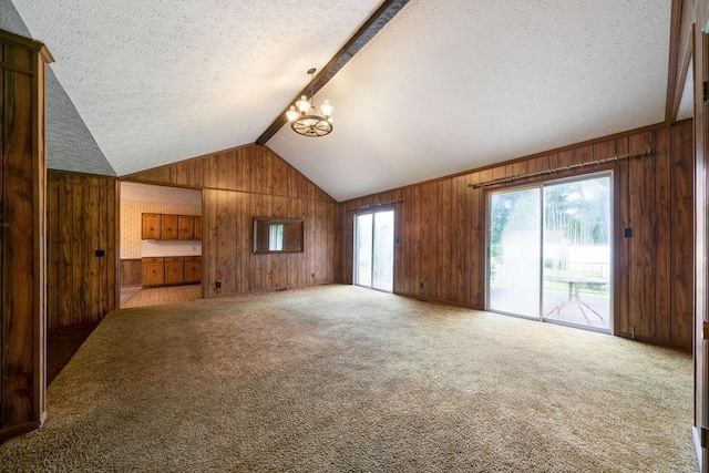 101 Beaver Run, Lagrange, GA 30241 - unfurnished living room with wooden walls, a textured ceiling, a chandelier, and carpet