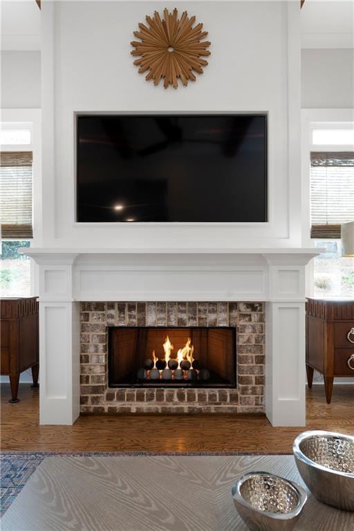 details featuring a brick fireplace and wood finished floors