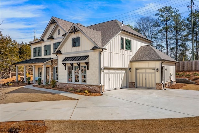 view of front of home featuring fence, roof with shingles, concrete driveway, board and batten siding, and brick siding