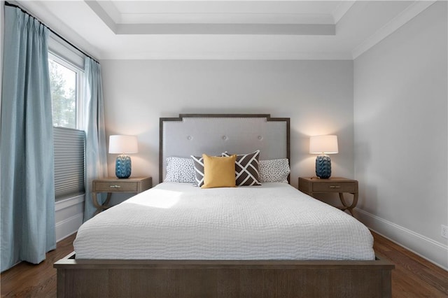 bedroom featuring a tray ceiling, dark wood-style floors, baseboards, and ornamental molding