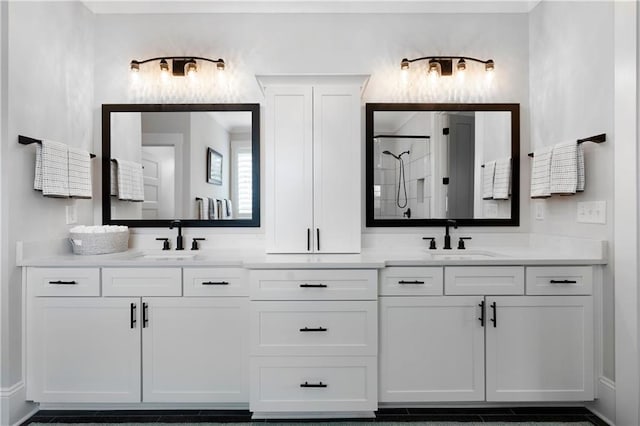full bath featuring a shower stall, double vanity, and a sink