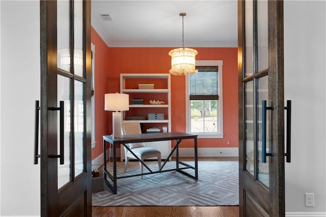 home office featuring baseboards, a notable chandelier, wood finished floors, and ornamental molding