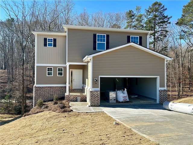 view of front of house with driveway, brick siding, and an attached garage