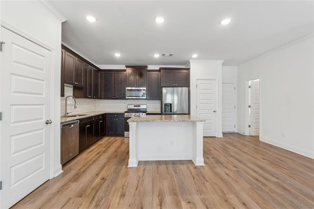 6761 Cedar Glen Rd, Peachtree Corners, GA 30360 - kitchen with stainless steel appliances, crown molding, dark brown cabinetry, tasteful backsplash, and a center island