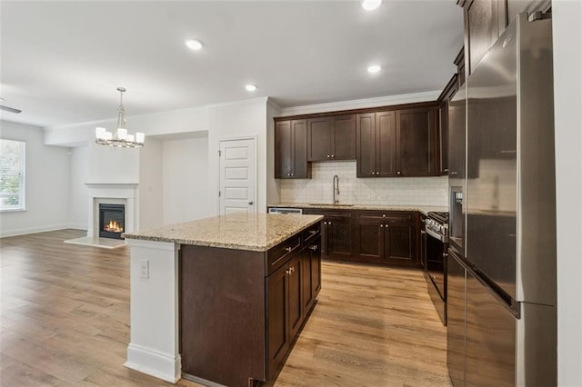 6761 Cedar Glen Rd, Peachtree Corners, GA 30360 - kitchen featuring stainless steel refrigerator with ice dispenser, stove, dark brown cabinets, a kitchen island, and open floor plan