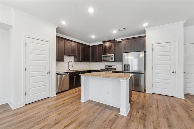 6761 Cedar Glen Rd, Peachtree Corners, GA 30360 - kitchen featuring appliances with stainless steel finishes, dark brown cabinets, ornamental molding, backsplash, and light wood-style floors