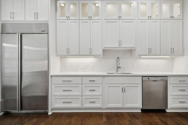 kitchen featuring stainless steel appliances, sink, dark wood-type flooring, and white cabinets