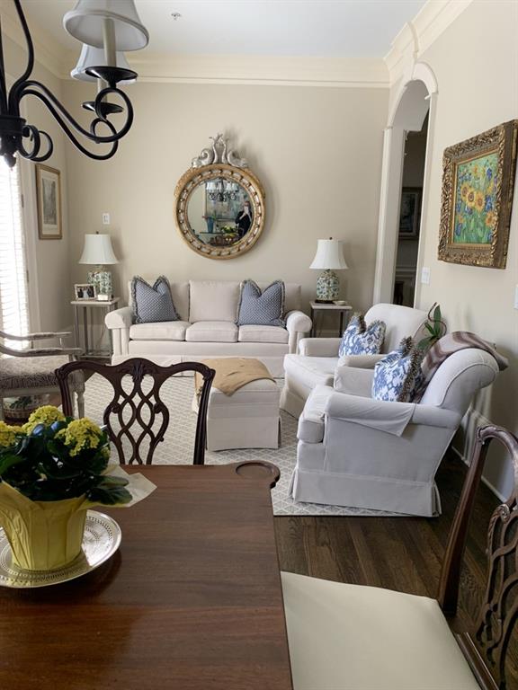 living room featuring hardwood / wood-style flooring, crown molding, and a notable chandelier