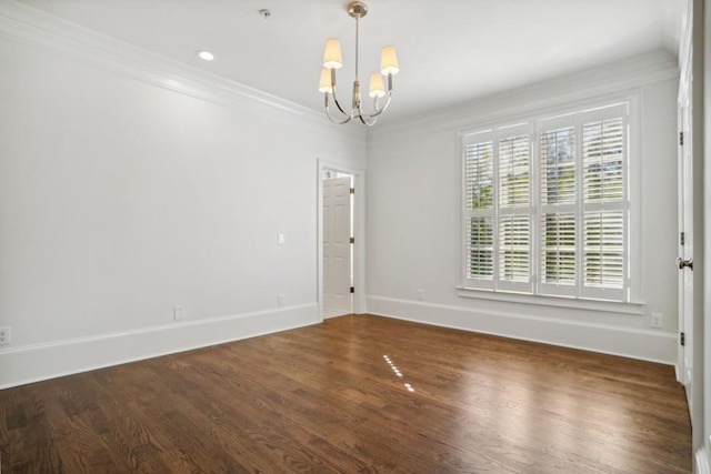 spare room featuring an inviting chandelier, ornamental molding, and dark hardwood / wood-style flooring