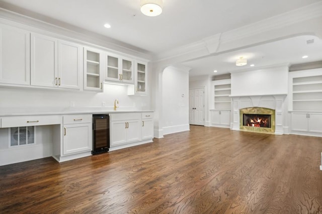 kitchen with white cabinetry, a high end fireplace, dark hardwood / wood-style floors, and wine cooler