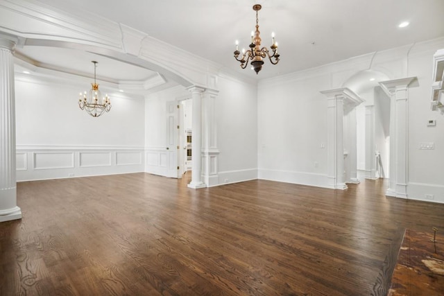 interior space with decorative columns, a notable chandelier, and dark hardwood / wood-style flooring