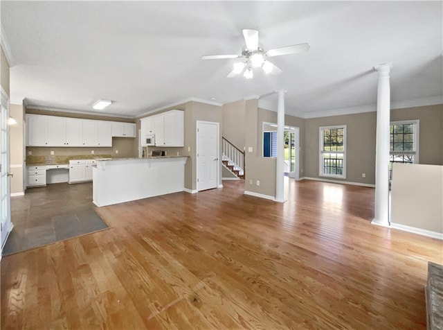 unfurnished living room with ceiling fan, decorative columns, crown molding, and hardwood / wood-style floors