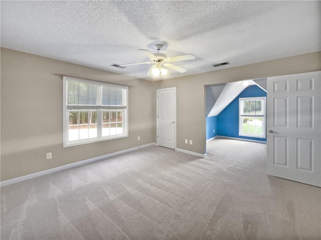 bonus room featuring ceiling fan, light colored carpet, and a textured ceiling