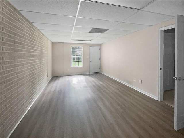 unfurnished room with a paneled ceiling and dark hardwood / wood-style flooring