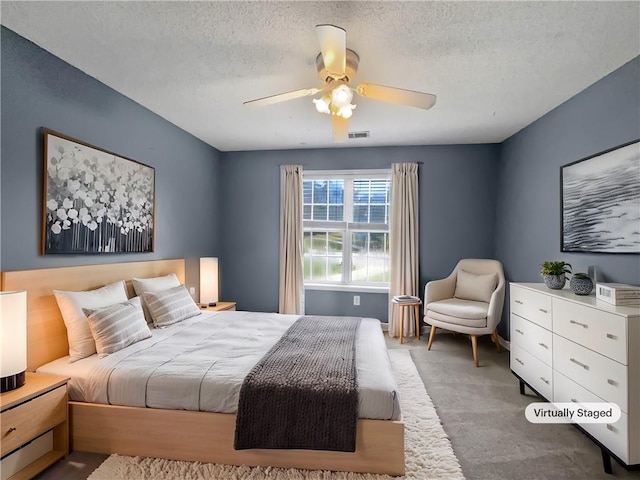 bedroom featuring ceiling fan, a textured ceiling, and carpet floors