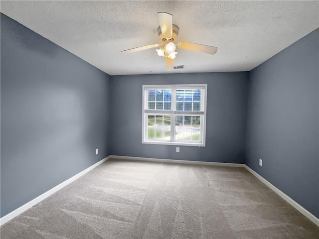 carpeted empty room with ceiling fan and a textured ceiling