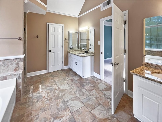 bathroom with vanity, lofted ceiling, ornamental molding, and a tub