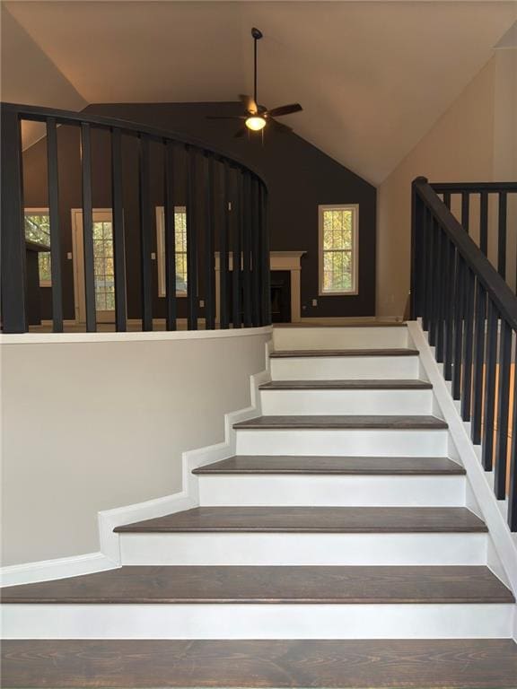 stairway with ceiling fan and vaulted ceiling