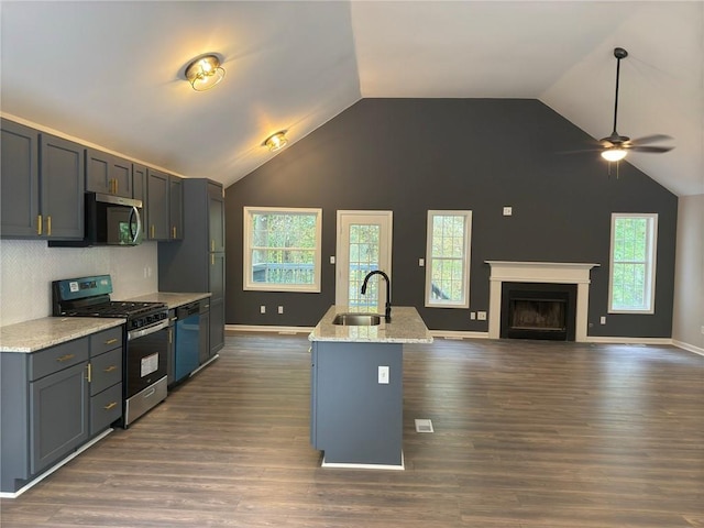 kitchen with a wealth of natural light, sink, a kitchen island with sink, and appliances with stainless steel finishes