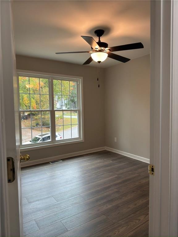 empty room featuring dark hardwood / wood-style flooring and ceiling fan