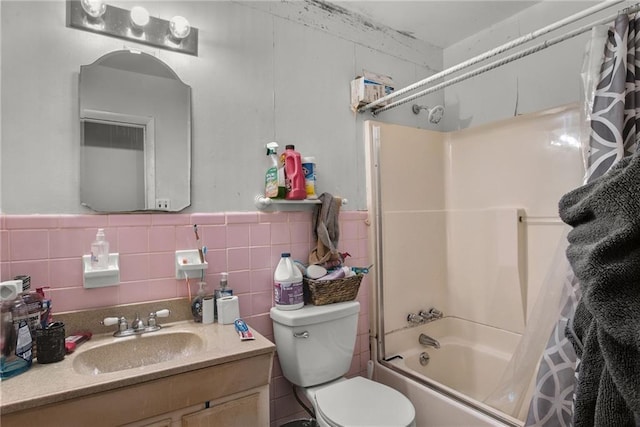 full bathroom with vanity, toilet, shower / tub combo, and tile walls