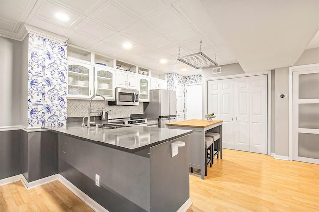 114 Emily Ln, Alpharetta, GA 30009 - kitchen featuring stainless steel appliances, a breakfast bar, light wood finished floors, a peninsula, and recessed lighting