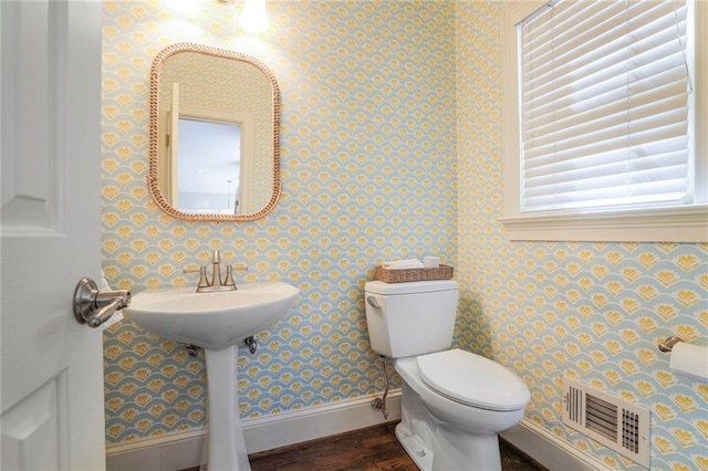 half bathroom with visible vents, toilet, baseboards, and wallpapered walls