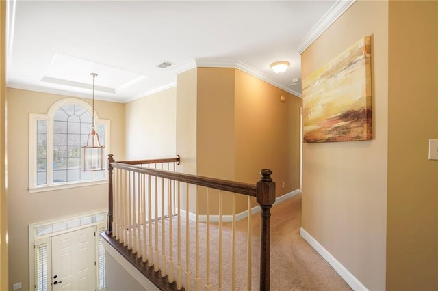 hallway with visible vents, ornamental molding, carpet flooring, an upstairs landing, and baseboards