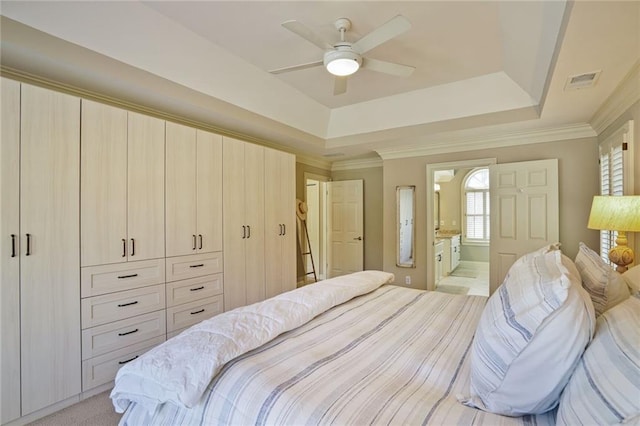 bedroom featuring a tray ceiling, visible vents, crown molding, and light carpet