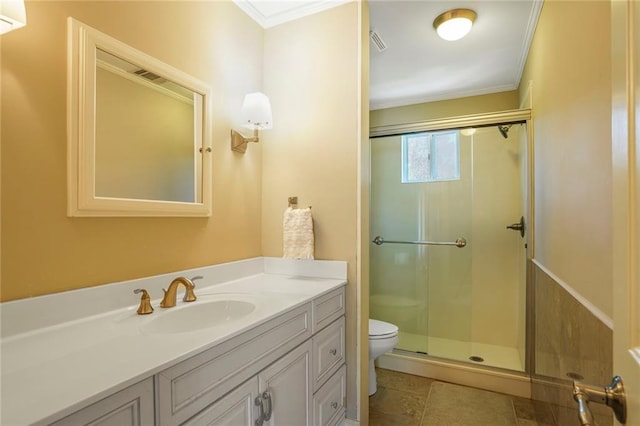 bathroom featuring a stall shower, toilet, tile patterned flooring, crown molding, and vanity