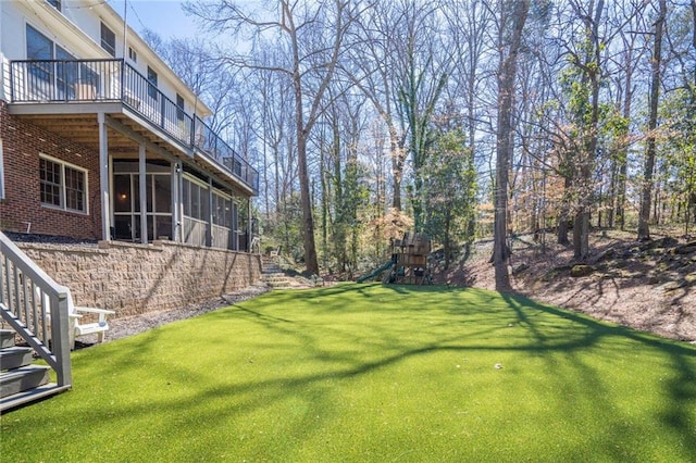 view of yard featuring a sunroom, a playground, and stairs