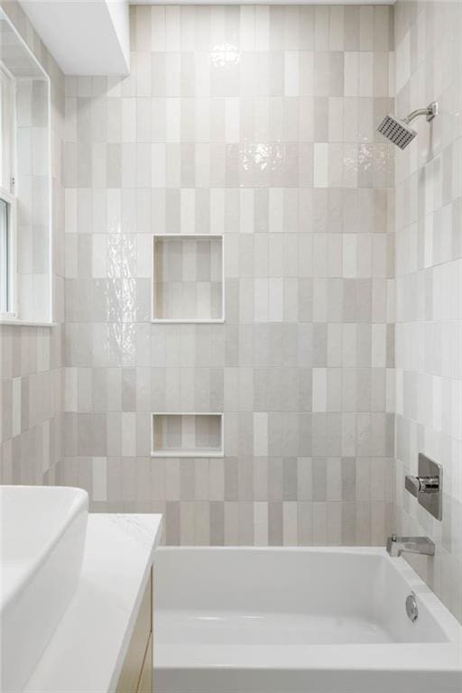 bathroom featuring vanity and tiled shower / bath combo