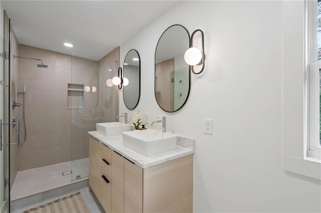 bathroom featuring tile patterned floors, a tile shower, and vanity