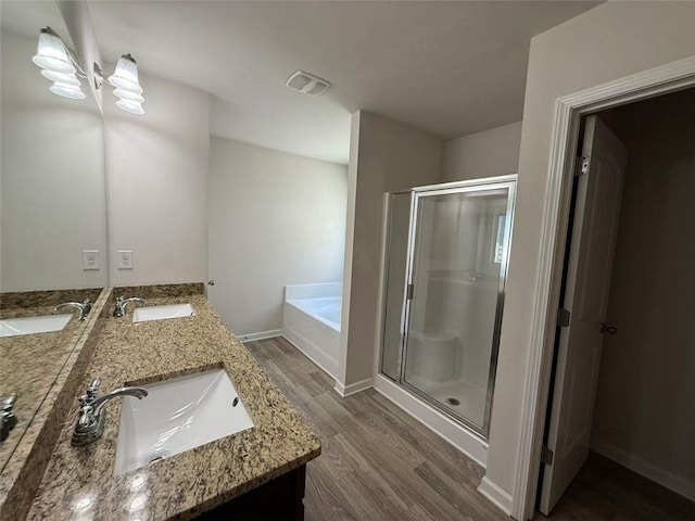 6474 Grey Fox Way, Riverdale, GA 30296 - bathroom featuring wood finished floors, a shower stall, a bath, double vanity, and baseboards