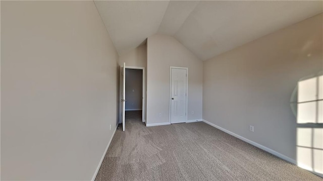 unfurnished bedroom with baseboards, carpet floors, and lofted ceiling